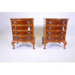 A pair of commode style wood bedside chests, with four drawers each, brass handles and carved