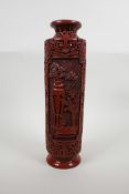 A cinnabar lacquer style sleeve vase with decorative panels depicting objects of virtue, seal mark