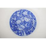 A Chinese blue and white ceramic charger, decorated with prunus blossom in cracked ice, late C19th/