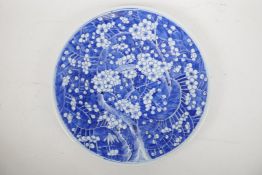 A Chinese blue and white ceramic charger, decorated with prunus blossom in cracked ice, late C19th/