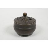 A Chinese bronze censer with a pierced cover decorated with a dragon, marked to base, 3" diameter