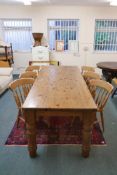 A pine farmhouse table, raised on screw in turned supports and six spindle back beech chairs, 36"