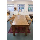 A pine farmhouse table, raised on screw in turned supports and six spindle back beech chairs, 36"