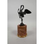 A bronzed metal figure of a crane standing on a tortoise entwined by a snake, on a marbled stone
