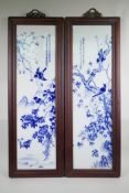 A pair of Chinese blue and white porcelain panels in hardwood frames, decorated with birds amongst