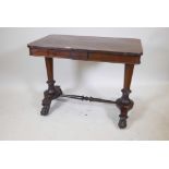 A Victorian rosewood centre table on shaped end supports, united by a turned wood stretcher, 36" x