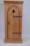 A reclaimed pine cupboard with arched door and metal strap hinges, raised on a plinth base, 23" x