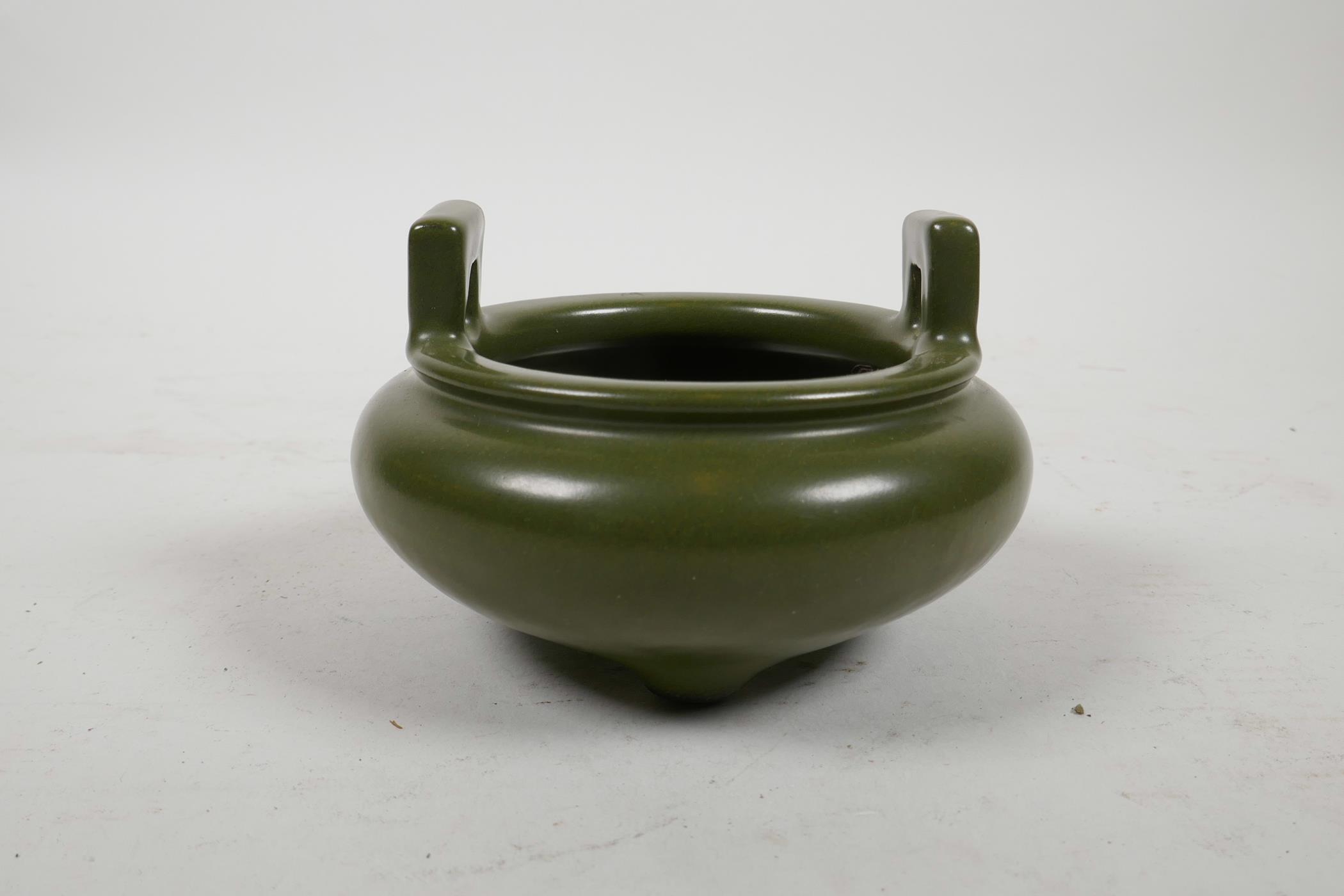 A Chinese tea dust glazed pottery censer with two handles and tripod supports, impressed seal mark