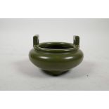 A Chinese tea dust glazed pottery censer with two handles and tripod supports, impressed seal mark