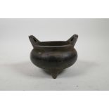 A Chinese bronze censer on tripod supports with phoenix eye handles, 4½" diameter