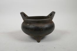 A Chinese bronze censer on tripod supports with phoenix eye handles, 4½" diameter