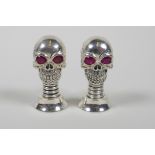 A pair of condiments in the form of skulls, stamped 800, 2"