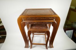 Three oriental carved wood nesting tables on swept supports, largest 24" high x 21" wide x 14" deep