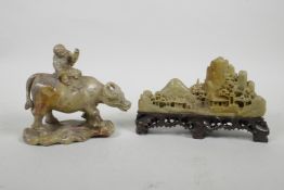 A Chinese soapstone carving of a child riding a buffalo, together with another similar carved