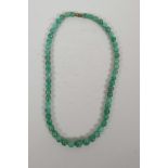 A graduated green jade bead necklace, 17" long