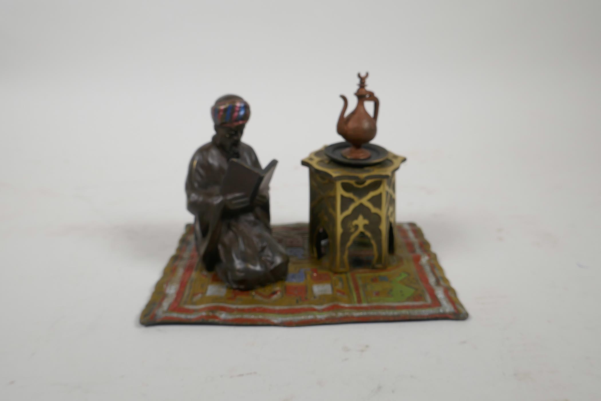 A cold painted bronze figure of a Moor on a carpet, impressed 'B' to base, 6" x 4"