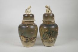 A pair of Japanese pottery jars and covers, decorated with waterfowl and petals, the covers with