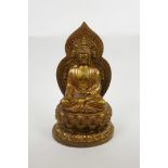 A Chinese metal figure of Buddha seated on a lotus throne with gilt and coppered patina, four