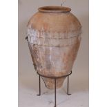 A terracotta amphora olive jar and wrought iron stand, 36" high