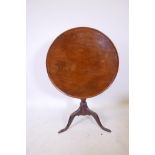 A Georgian mahogany tilt top occasional table with single piece dished top, raised on a turned