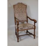 A Continental walnut high back open armchair, with scrolled end arms and shaped back, raised on