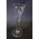 A large Georgian clear glass wine flute on rolled foot, 6½" high