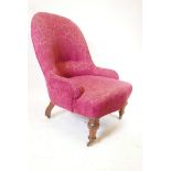 A Victorian nursing chair raised on turned walnut supports