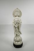 A Chinese blanc de chine Quan Yin on a lotus flower, on an associated hardwood stand, impressed seal