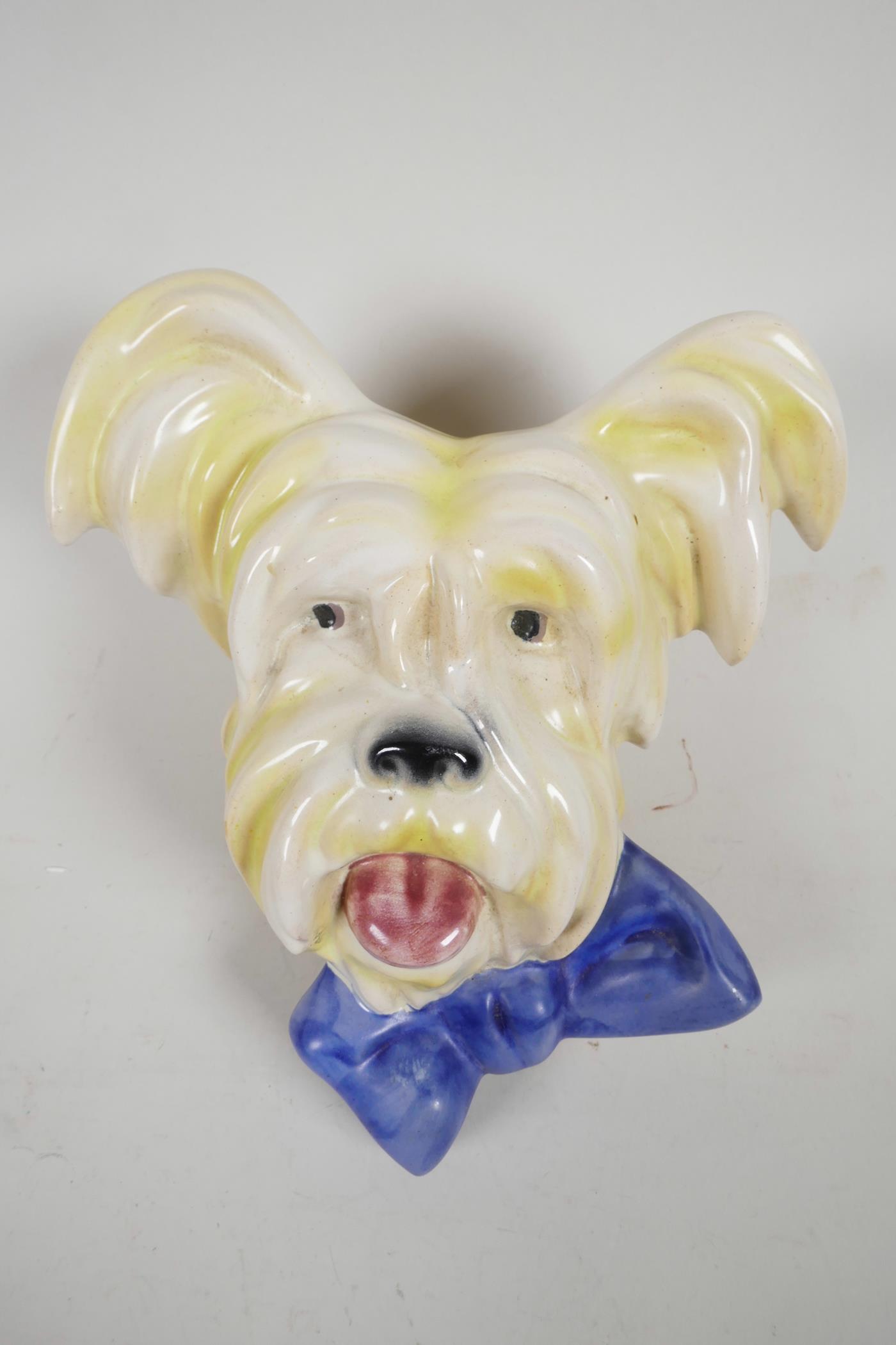 An Art Deco terrier head ceramic wall plaque with blue bow tie, hook verso, 8" high x 6½? wide