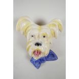 An Art Deco terrier head ceramic wall plaque with blue bow tie, hook verso, 8" high x 6½? wide
