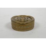 A gilt metal cylinder patch box with heraldic eagle decoration to cover, 2½" diameter