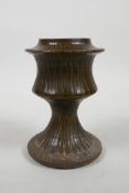 An early stoneware vase with a fluted body and treacle glaze, 5½" high