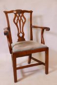 An early C19th walnut Chippendale style elbow chair with pierced and carved splat back, and scroll