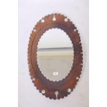 A wall mirror with tooled leather frame, 29" high
