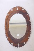 A wall mirror with tooled leather frame, 29" high
