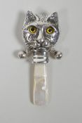 A sterling silver baby's rattle in the form of a cat, with mother of pear handle, 3" long
