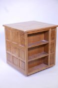 A 'Wrenman' Robert Hunter oak bookcase, with three open sides and cupboard, the fourth adzed top and