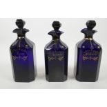 A trio of Georgian Bristol blue glass decanters of square sectional form, the shoulders faceted, all
