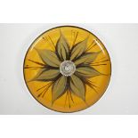 A studio pottery wall plate decorated with a flower, signed, 10½"diameter