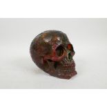 A faux amber skull with raised magical esoteric and symbol decoration, 5½" high