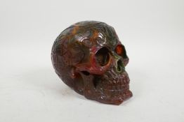 A faux amber skull with raised magical esoteric and symbol decoration, 5½" high