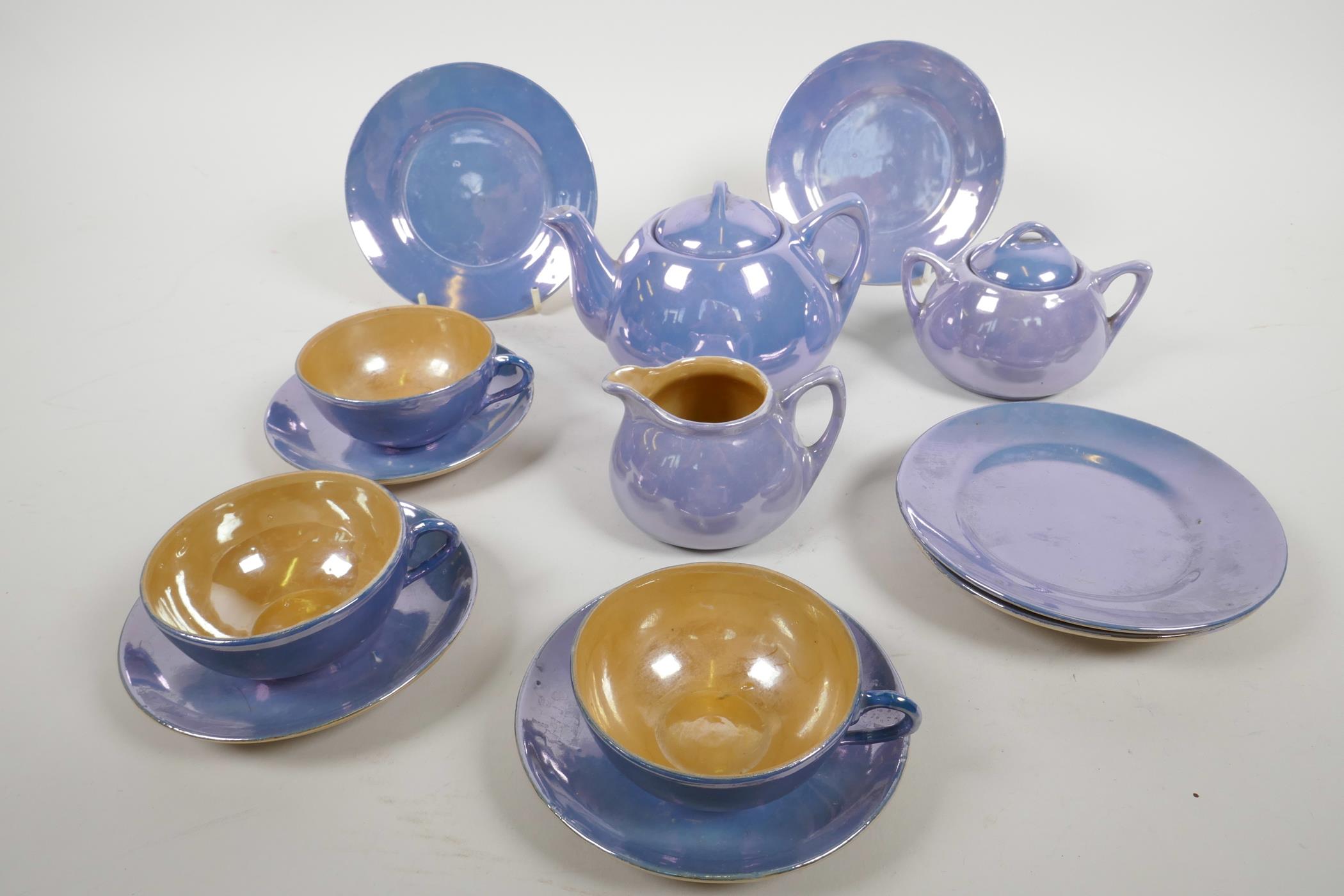 A mid C20th Staffordshire lustreware child's miniature tea service, comprising a teapot, sugar bowl,