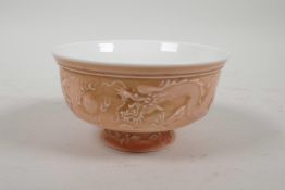 A Chinese pink glazed porcelain stem bowl with raised dragon and flaming pearl decoration, 2½"