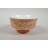 A Chinese pink glazed porcelain stem bowl with raised dragon and flaming pearl decoration, 2½"