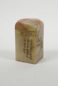 A Chinese soapstone seal with carved floral and character decoration, 2" x 2" x 3½" high