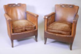 A pair of 1930s Continental leather easy chairs, with sprung seats and brass stud decoration, raised