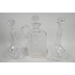 Two cut and moulded glass wine decanters with stoppers, 9½? high together with a flattened claret