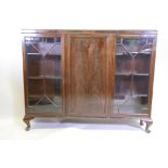 A 1930s mahogany bookcase with three doors, (two glazed), on cabriole supports, 53" x 9½" x 42½"
