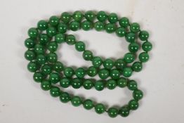 A string of green jade beads, 32" long