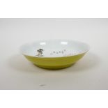 A Chinese yellow ground porcelain bowl with famille verte bird and flower decoration to the